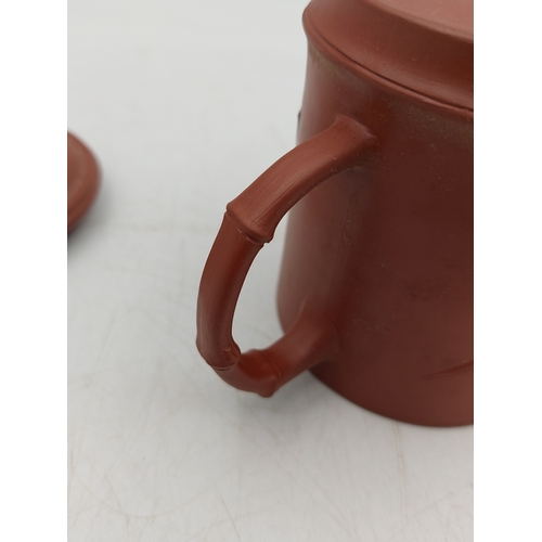 273 - A Chinese Yixing Zisha clay lidded tea mug featuring bamboo-themed decorations.
