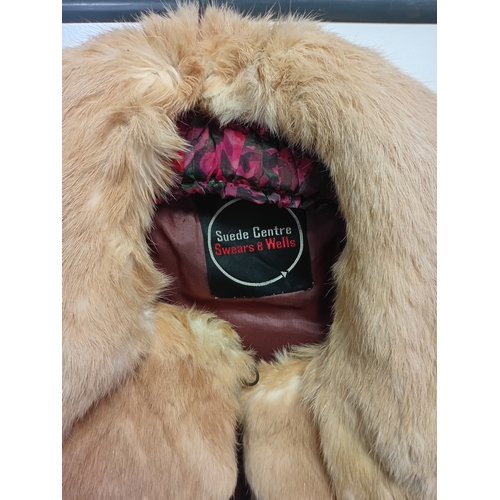 284 - A pair of fur coats - a long leopard print coat with dark brown sleeve cuffs and collar, and a suede... 