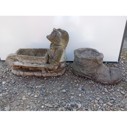181 - A pair of garden statues. To include boot shaped pot & hedge hog with a wheel barrow planter.