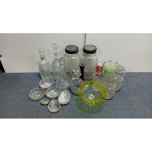 3 - A collection of decorative glass, including stoppered decanters and bottles, covered storage jars, a... 