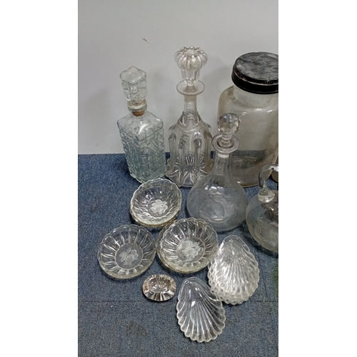 3 - A collection of decorative glass, including stoppered decanters and bottles, covered storage jars, a... 