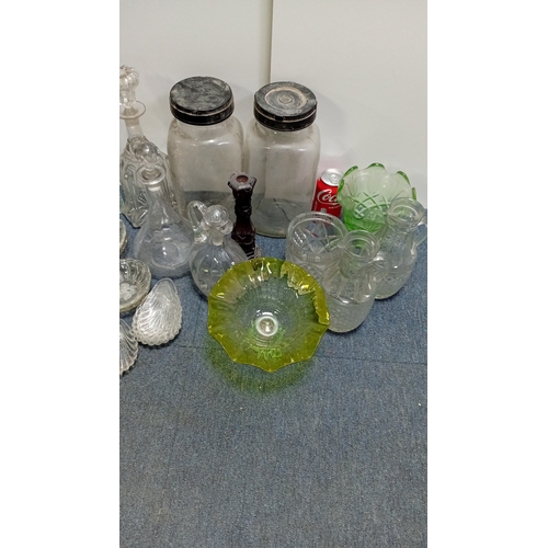 3 - A collection of decorative glass, including stoppered decanters and bottles, covered storage jars, a... 