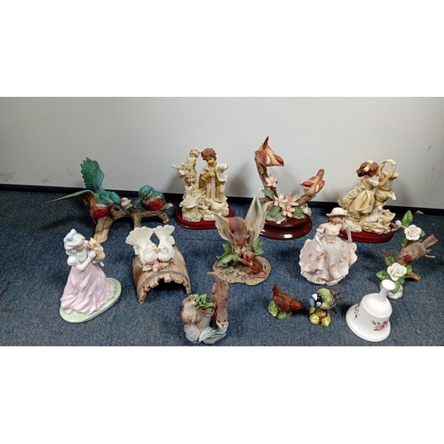 10 - A mixed group of decorative figurines and ornaments, including polychrome bird studies, resin figure... 
