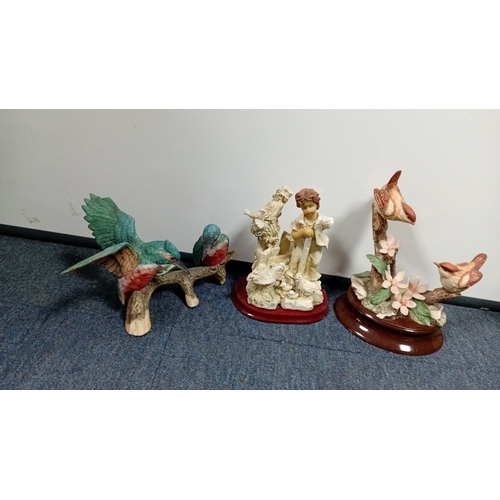 10 - A mixed group of decorative figurines and ornaments, including polychrome bird studies, resin figure... 