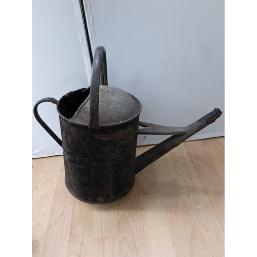 20 - A group of two garden watering vessels: a black-painted metal watering can with domed cover and hand... 