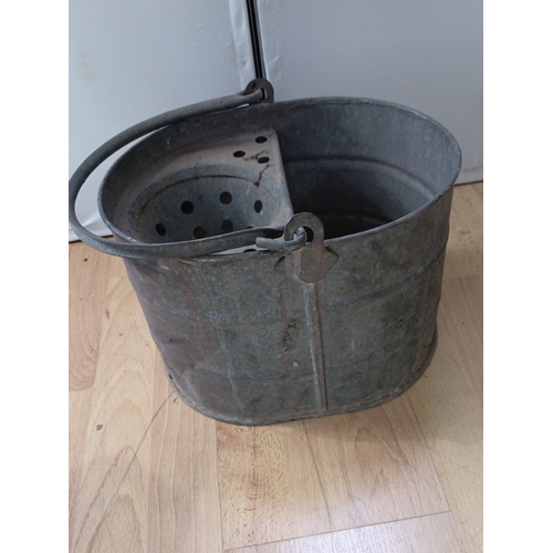 20 - A group of two garden watering vessels: a black-painted metal watering can with domed cover and hand... 