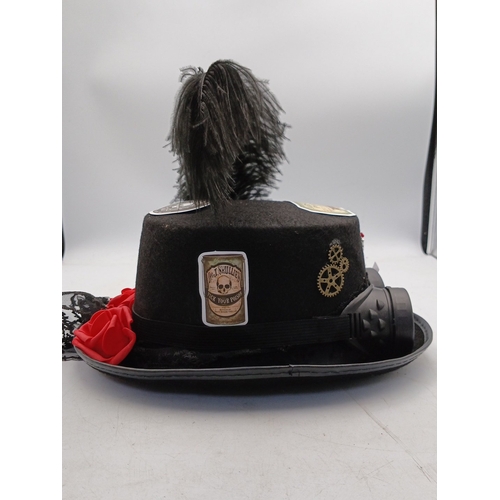 21 - Steampunk-inspired black felt top hat, embellished with feather plume, faux goggles, applied gear mo... 