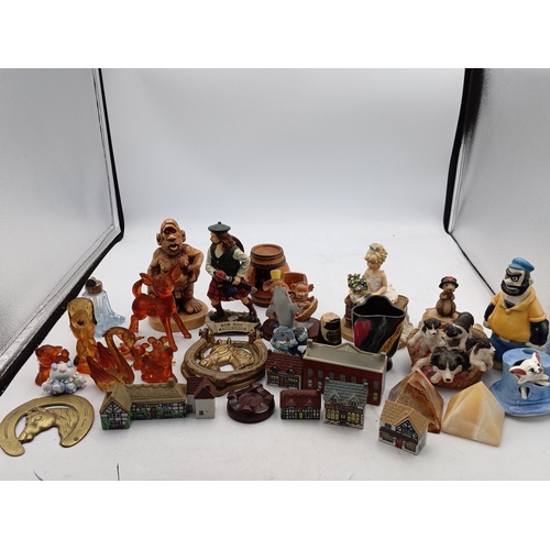 23 - A mixed group of small decorative collectables, including resin and ceramic figurines, model buildin... 