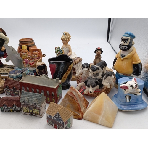 23 - A mixed group of small decorative collectables, including resin and ceramic figurines, model buildin... 