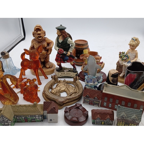 23 - A mixed group of small decorative collectables, including resin and ceramic figurines, model buildin... 