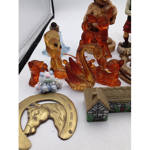 23 - A mixed group of small decorative collectables, including resin and ceramic figurines, model buildin... 