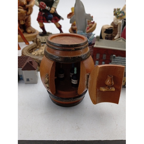 23 - A mixed group of small decorative collectables, including resin and ceramic figurines, model buildin... 