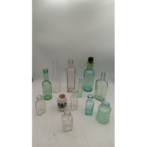 41 - A group of embossed glass bottles in aqua and clear, including stout, medicinal and rectangular form... 