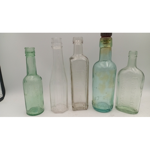 41 - A group of embossed glass bottles in aqua and clear, including stout, medicinal and rectangular form... 