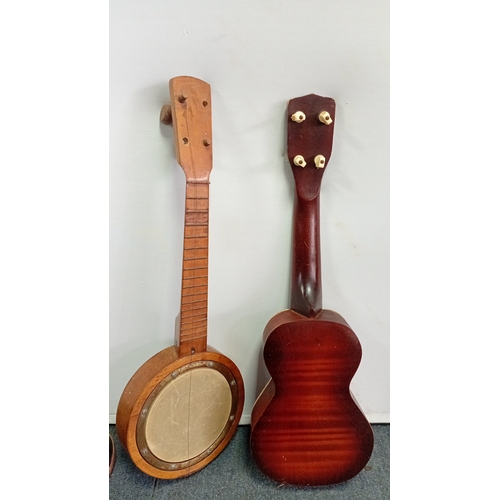 69 - A group of fretted instruments comprising a Harmony soprano ukulele with sunburst finish, a banjo-uk... 