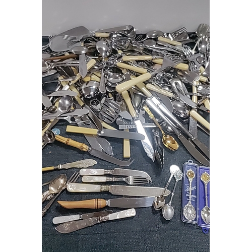 48 - A quantity of mixed flatware and serving implements, including silver plated and stainless steel cut... 