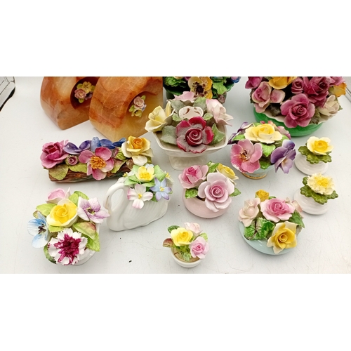50 - A group of assorted porcelain floral encrusted ornaments and posy holders, including miniature vases... 
