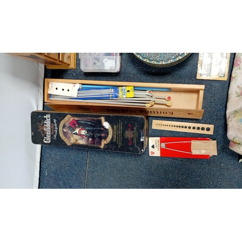 56 - A mixed group of sewing and knitting requisites, including a cat-decorated wooden drawer box, tins, ... 