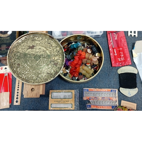 56 - A mixed group of sewing and knitting requisites, including a cat-decorated wooden drawer box, tins, ... 