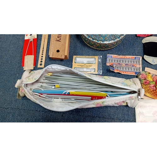 56 - A mixed group of sewing and knitting requisites, including a cat-decorated wooden drawer box, tins, ... 