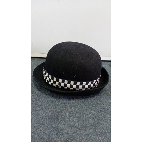62 - British police custodian helmet of domed black felted construction, with blue-and-white chequered ba... 