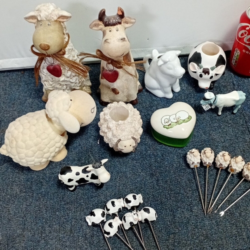 63 - A collection of novelty farm-animal ornaments in painted resin and ceramic, including cow and sheep ... 