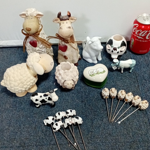 63 - A collection of novelty farm-animal ornaments in painted resin and ceramic, including cow and sheep ... 