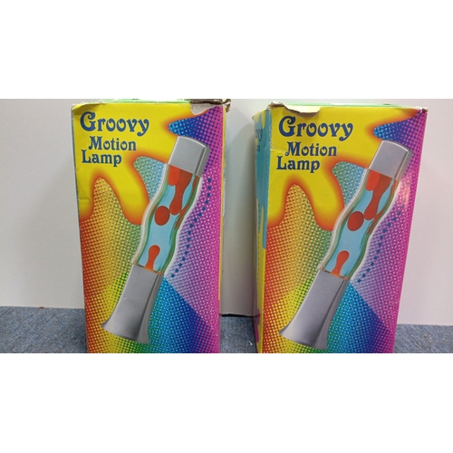 66 - A pair of “Groovy Motion Lamp” table lamps, each with a square-section base and cap framing a waiste... 