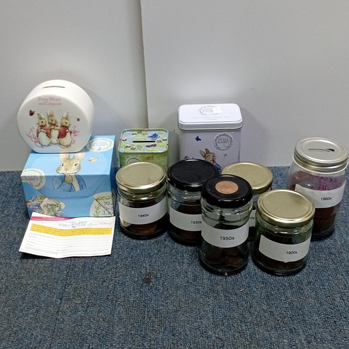 69 - A group of Peter Rabbit-related items including a ceramic money bank, a tea tin, a floral tin box, a... 