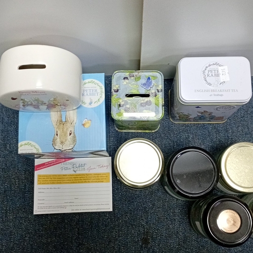 69 - A group of Peter Rabbit-related items including a ceramic money bank, a tea tin, a floral tin box, a... 