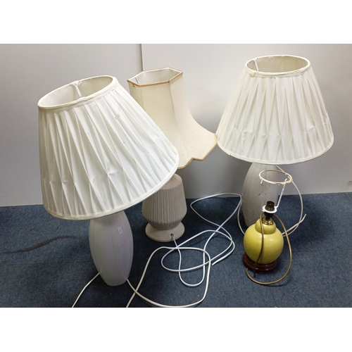 71 - A group of three electric table lamps comprising two white marble-effect baluster lamps with pleated... 