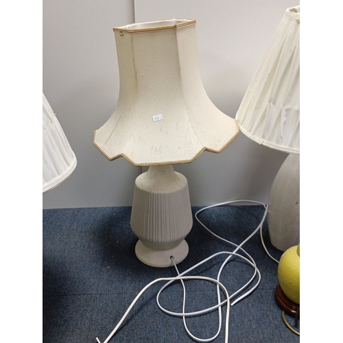 71 - A group of three electric table lamps comprising two white marble-effect baluster lamps with pleated... 