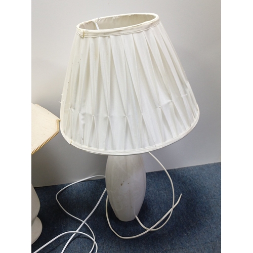 71 - A group of three electric table lamps comprising two white marble-effect baluster lamps with pleated... 
