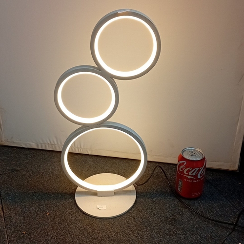73 - Modern white metal table lamp with three circular LED light rings in graduated sizes, arranged asymm... 