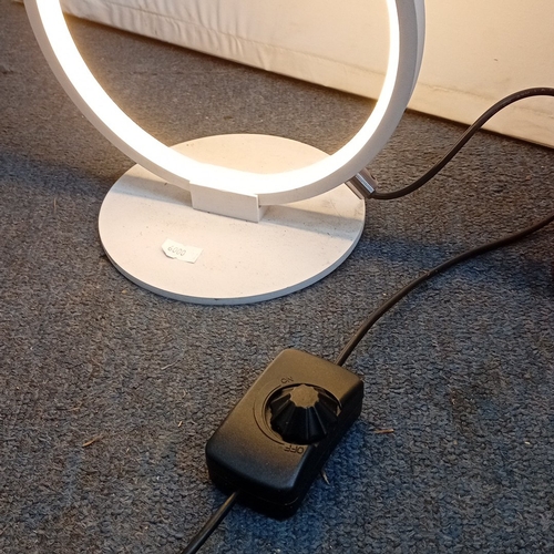 73 - Modern white metal table lamp with three circular LED light rings in graduated sizes, arranged asymm... 
