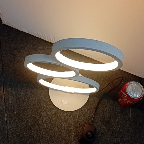 73 - Modern white metal table lamp with three circular LED light rings in graduated sizes, arranged asymm... 