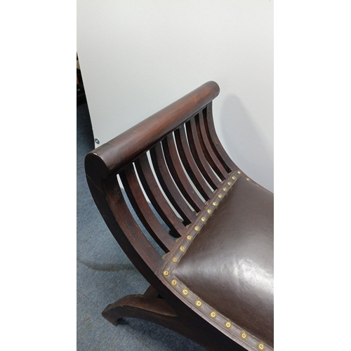 119 - A vintage curved mahogany bench, the bowed ends with arched slatwork rising to cylindrical crest rai... 