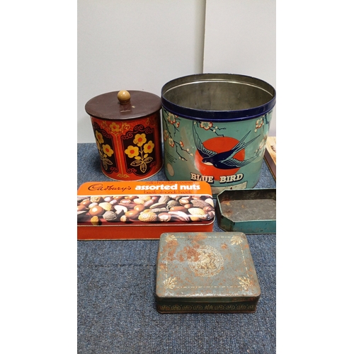 82 - An assortment of vintage printed tin containers including a Cadbury’s assorted nuts tin, a large “Bl... 