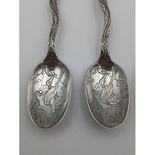 239 - A set of four tested silver dragon spoons depicting a bird on a lotus tree.