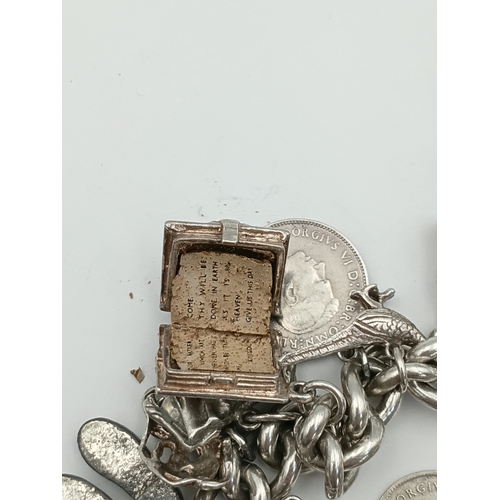 370 - A hallmarked silver curb link chain bracelet with a padlock clasp, including various silver charms f... 