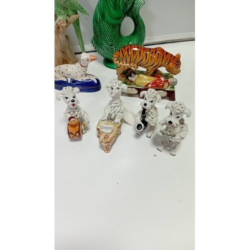 10 - A group of glazed ceramic animal figures and novelty wares, including a model cow, perched parrot, t... 