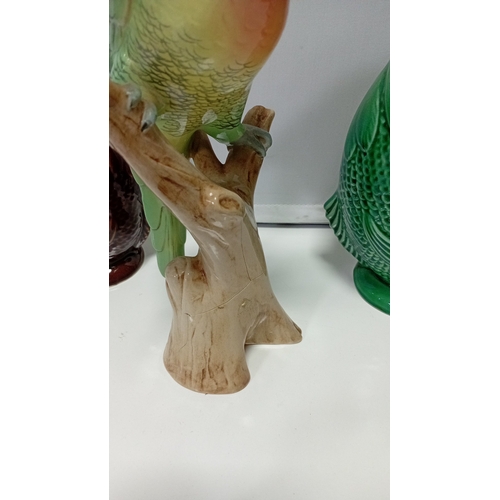 10 - A group of glazed ceramic animal figures and novelty wares, including a model cow, perched parrot, t... 