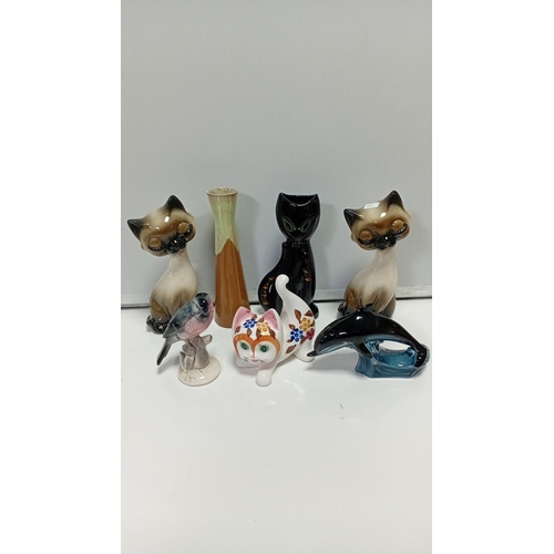 11 - A group of glazed ceramic animal figures comprising two Siamese-style cats, a black cat, a stylised ... 