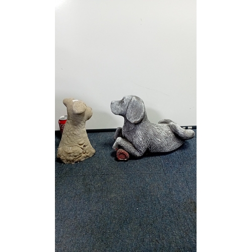 22 - A group of two composite garden ornaments modelled as dogs: one seated terrier-type figure and one r... 