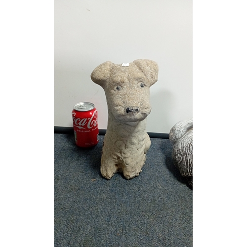 22 - A group of two composite garden ornaments modelled as dogs: one seated terrier-type figure and one r... 