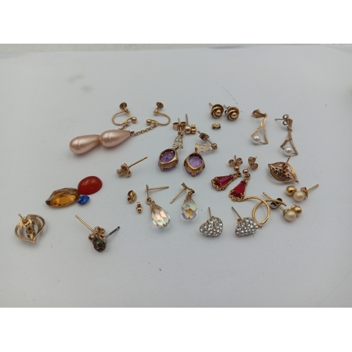 116 - A collection of 9ct gold & yellow metal earrings & loose stones. Total weight 15.19 grams.
