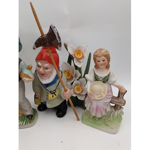 23 - A quantity of painted ceramic and resin figural ornaments, including rustic characters, child figure... 