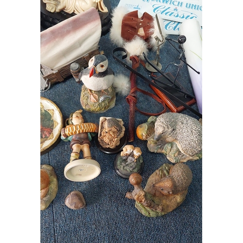 58 - A mixed lot of decorative objects including assorted resin animal figures, a metal skier sculpture, ... 