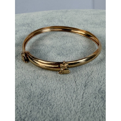 A 9ct yellow gold baby bangle with teddy bear details adjustable.