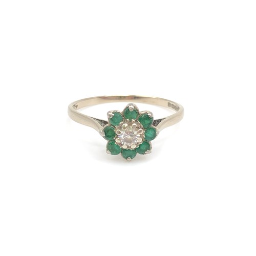 168 - Emerald and diamond flower ring with a central claw set diamond surrounded by six emerald petals in ... 